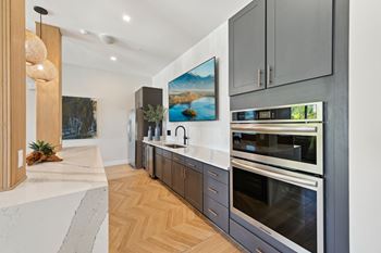 A modern kitchen with a marble countertop and stainless steel appliances.